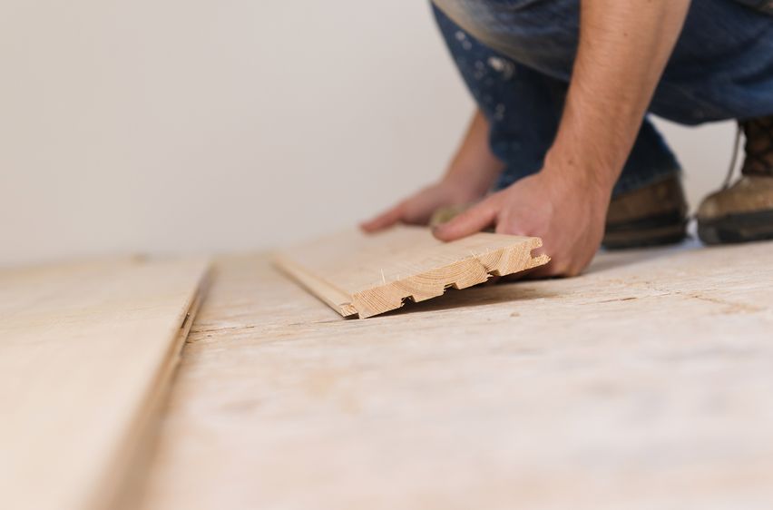 29021473 - handyman installing wooden floor in new house